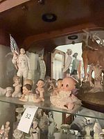 Group view of figurines, doll and deer on shelf