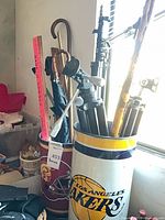 Tripods, canes, umbrella and decorative tins in window light