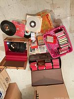 Overview of mixed media lot showing 8-track cartridges, 45s, cassettes and storage cases