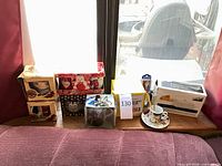 Entire lot on windowsill showing boxed mugs, butter dish, espresso cup and packaged spoon