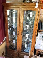 full view of oak curio cabinet showing doors, drawers and contents