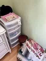 Plastic 5-drawer unit, blankets and red tin visible