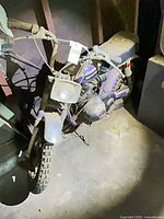 Full view of front and left side showing frame, wheel, handlebar, seat area