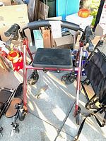 overhead view of red rollator walker showing seat, handles and wheels