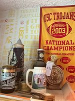 Group shot showing both steins, San Miguel jug and USC banner