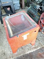 Front and top view of orange sandblasting cabinet showing size, color and overall form