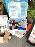 Overall view of six beverage containers in plastic tote