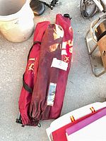 Three red USC camp chair bags on ground