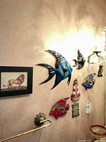 Overview showing ceramic wall fish, lighthouse plaque, framed lion print