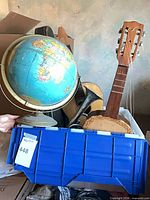 Globe, small guitar neck, brass cornet, crate view