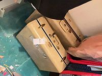 Two beige hard-shell suitcases stacked on floor