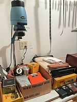 Overall lot with enlarger, boxed items, timer, measuring vessels, film boxes, cameras, case