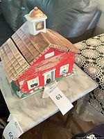 Full view of red ceramic schoolhouse cookie jar on table