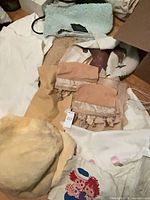 assortment laid out showing horse towel, tassel trims, plush cloth, doilies, Raggedy Ann print