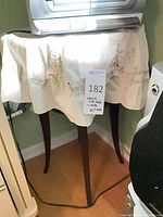 Full view of side table covered by cloth showing legs and overall form