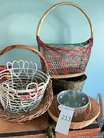 Group shot showing multicolour wicker basket on top, white wire basket nested in brown wicker basket, bronze planter and galvanized pail visible