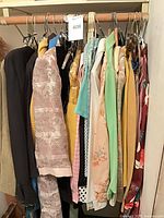 Rack of assorted women's garments on hangers showing variety of colors and styles