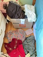 Overall view of clothes inside and around box