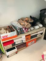 Shelf holding multiple shoeboxes with shoes on top