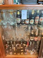 Cabinet shelf with Hard Rock Cafe pilsner glasses, shot glass, stemmed goblets visible