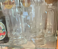 Two Hard Rock Cafe San Juan glass mugs on shelf