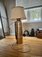 Full view of brass fire-extinguisher lamp with shade and cord