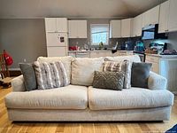 Front view of beige sofa with decorative pillows