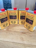 All four cans standing on floor showing front labels