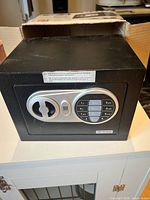 Front view of black electronic safe showing keypad and handle