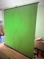 Front view of fully extended green screen showing fabric and base