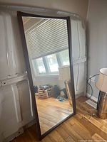 Full view of mirror standing against wall