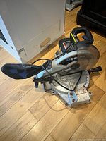 Full view of Delta Shopmaster 10" miter saw with dust bag attached on floor
