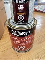 Gel stain can stacked on wood conditioner can, showing labels