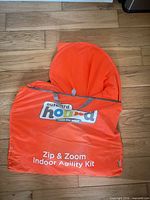 Front view of folded orange Outward Hound Zip & Zoom Indoor Agility Kit bag