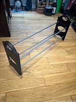 Full view of shoe rack showing metal rods and plastic ends