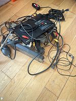 Tangled lot showing Blu-ray player, surge protector, cables, remote