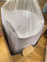 Sleeve of white cone strainers inside open box