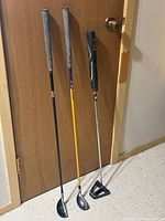 Three golf clubs upright showing full length and grips