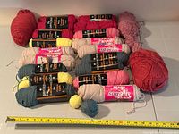 Group view of all skeins and balls with measuring tape for scale