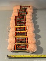 Ten peach Sayelle skeins aligned with measuring tape