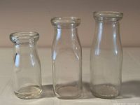 Front view of three milk bottles showing size differences