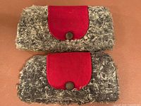 Front view of both sheep wool hats showing red flaps and buttons