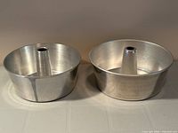 Both aluminum cake pans side by side showing size difference