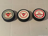 Top view of three championship pucks showing event graphics