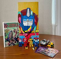 Group shot showing comic, canvas, figures, vehicles, promo card