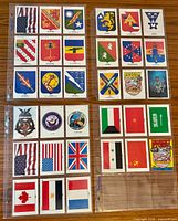 Fronts of cards 1-18 in plastic sheet showing coalition shields, flags and crests