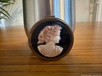 front view showing carved shell cameo on compact