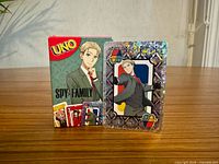 Front of sealed Spy x Family UNO box beside holographic card