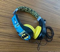 Headphones folded with Batman graphic visible on earcup and patterned headband