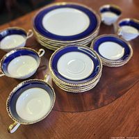 Stacked view of plates and cups showing cobalt blue and gold decoration